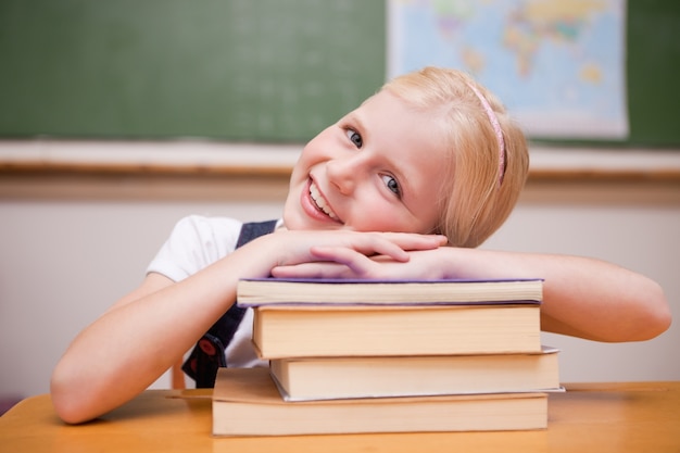 Jeune fille souriante, s&#39;appuyant sur des livres