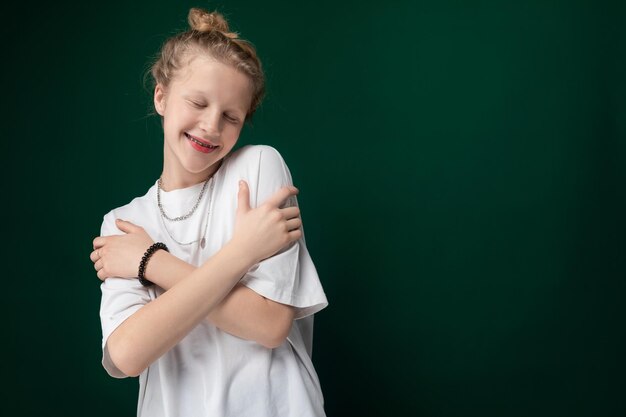 Une jeune fille souriante et serrant les bras.