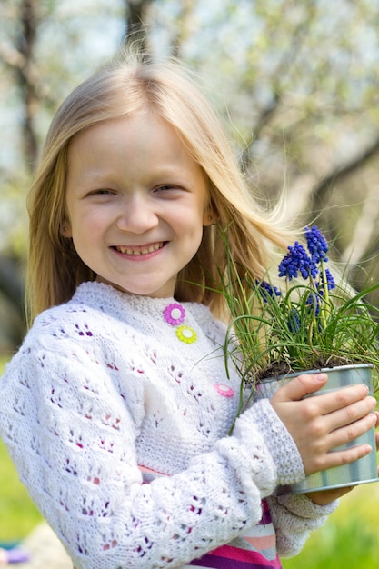 Jeune fille souriante tenant des jacinthes de fleurs dans un pot