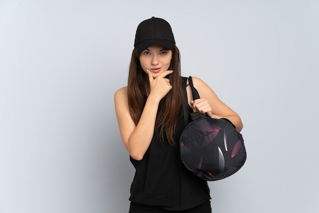 Jeune fille de sport avec sac de sport isolé sur la pensée grise