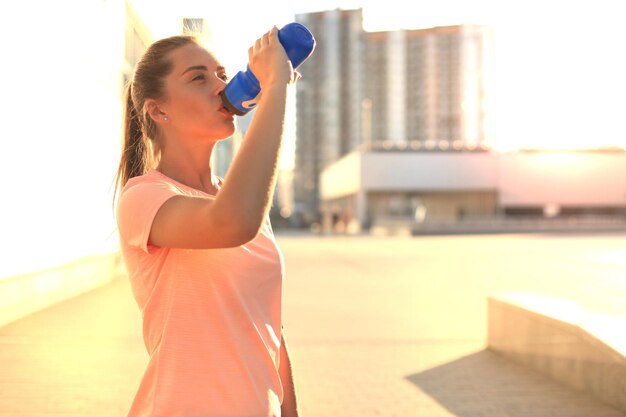 Jeune fille sportive attirante faisant une pause de l'exercice