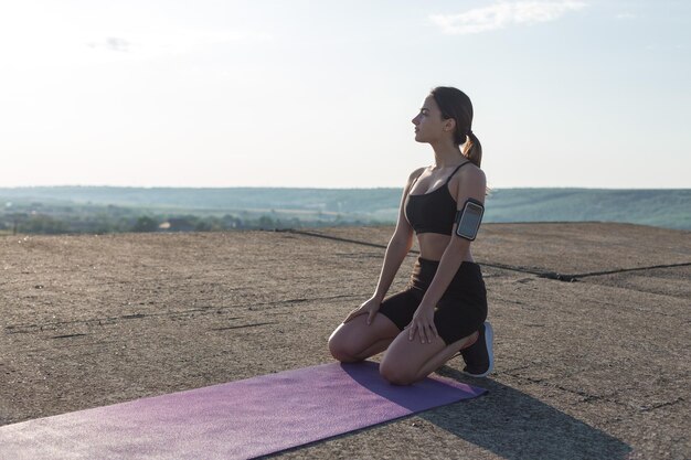 Une jeune fille sportive mince en tenue de sport exécute une série d'exercices Fitness et mode de vie sain