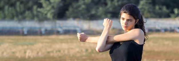 Une jeune fille sportive mince en tenue de sport avec des imprimés en peau de serpent effectue une série d'exercices