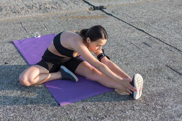 Une jeune fille sportive mince en tenue de sport avec des imprimés en peau de serpent effectue une série d'exercices