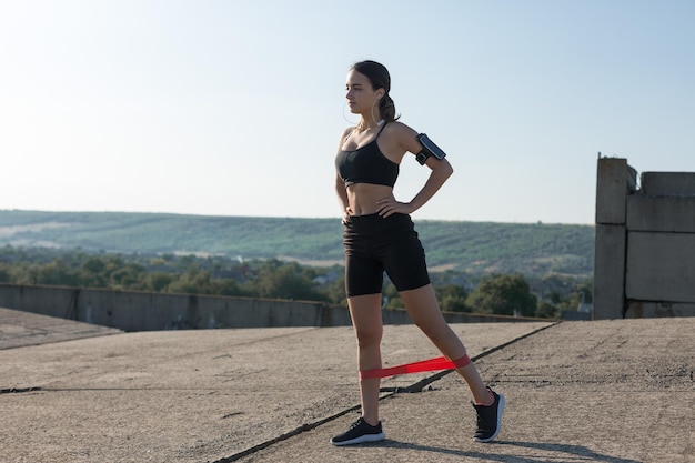 Une jeune fille sportive mince en tenue de sport avec des imprimés en peau de serpent effectue une série d'exercices