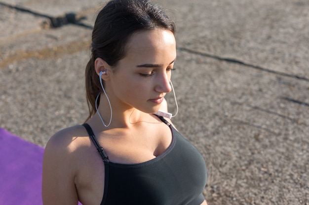 Une jeune fille sportive mince en tenue de sport avec des imprimés en peau de serpent effectue une série d'exercices