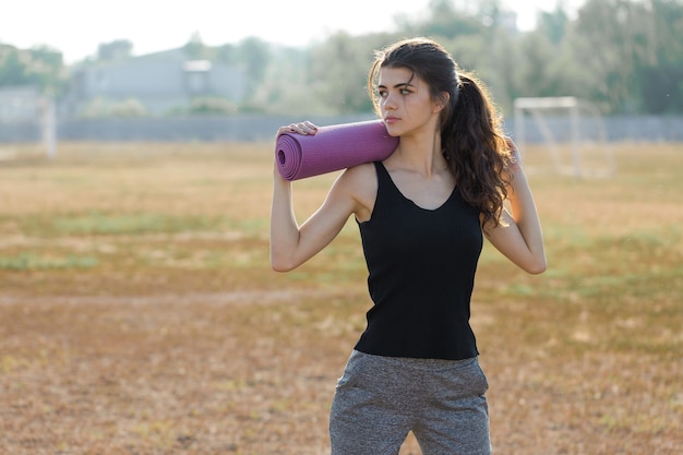 Une jeune fille sportive mince en tenue de sport avec des imprimés en peau de serpent effectue une série d'exercices