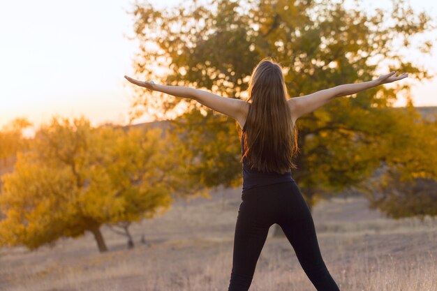 Une jeune fille sportive mince en tenue de sport avec des imprimés en peau de serpent effectue une série d'exercices