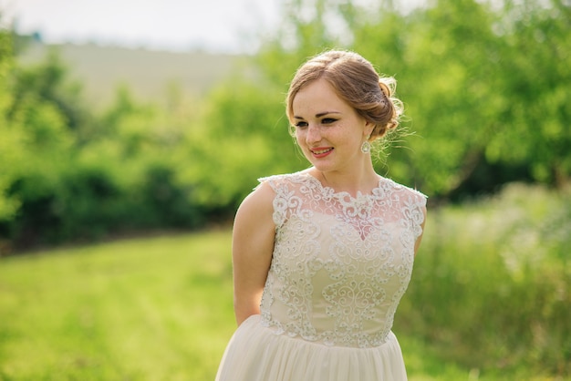 Jeune fille en surpoids à la robe beige a posé fond jardin printanier.