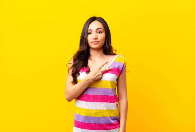 jeune fille en T-shirt coloré en forme de v sur la poitrine montrant la victoire ou la paix