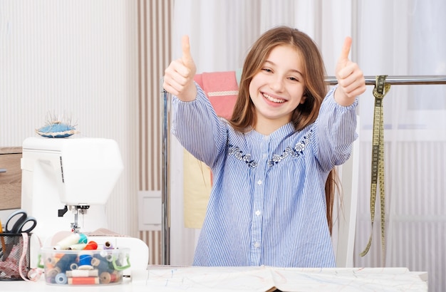 Jeune fille de tailleur avec les pouces vers le haut