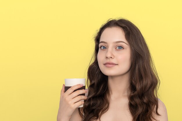 Une jeune fille avec une tasse en bambou réutilisable.