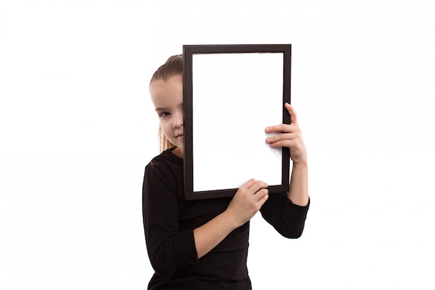 Jeune fille tenant une assiette vide sur un fond blanc