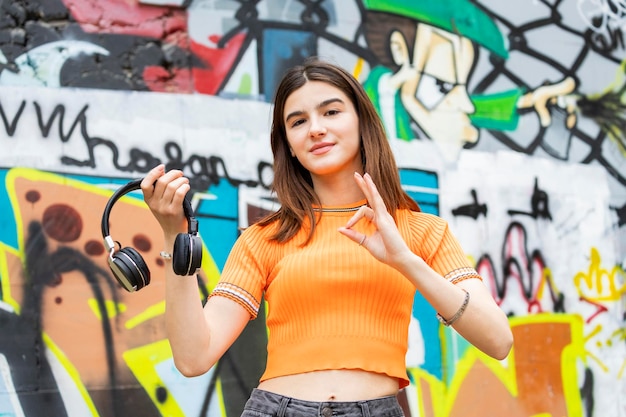 Jeune fille tenant un casque et geste OK