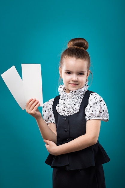 Jeune fille tenant deux papiers vierges et souriant