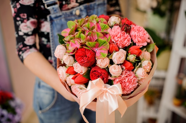 Jeune fille tenant un magnifique bouquet de fleurs lumineuses