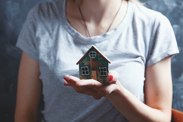 Jeune fille tenant une maison