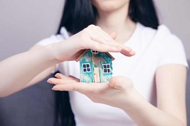 Jeune fille tenant une maison