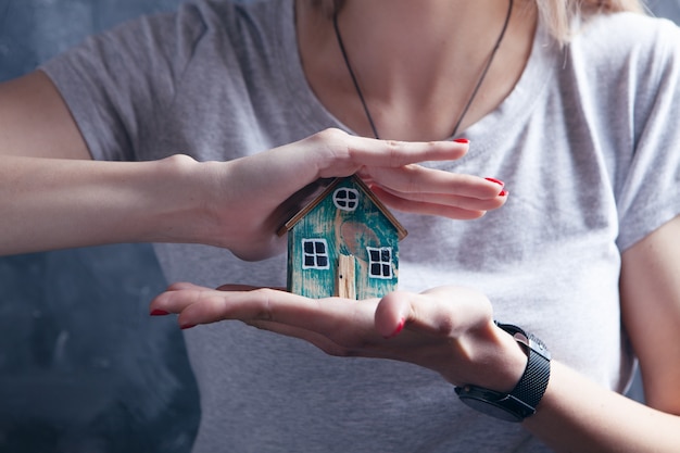 Jeune fille tenant une maison