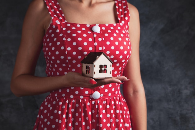 Jeune fille tenant une maison