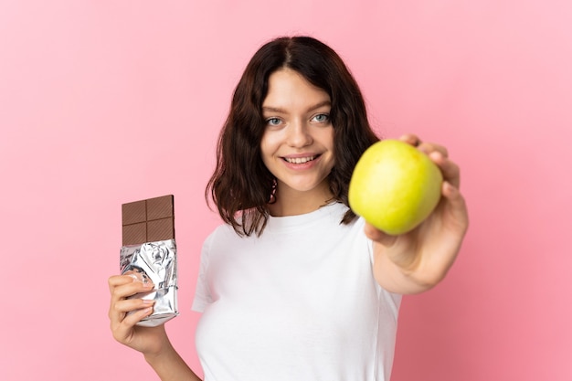 Jeune fille tenant une pomme et un chocolat