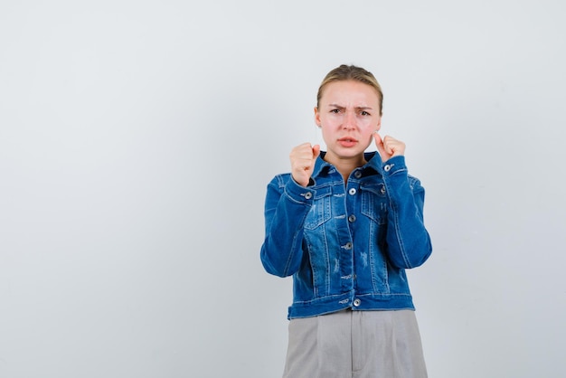 Jeune fille tenant ses poings sur fond blanc