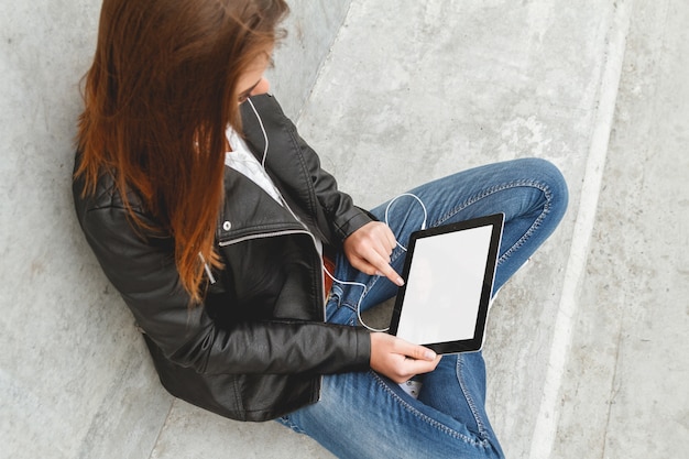 Une jeune fille tenant une tablette dans les mains