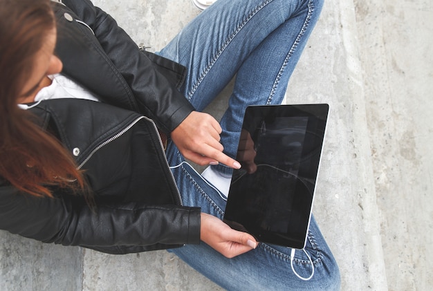 Une jeune fille tenant une tablette dans les mains