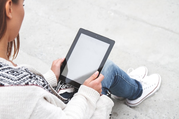 Une jeune fille tenant une tablette dans les mains