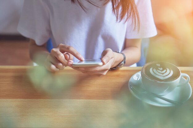 Jeune fille tenant un téléphone blanc