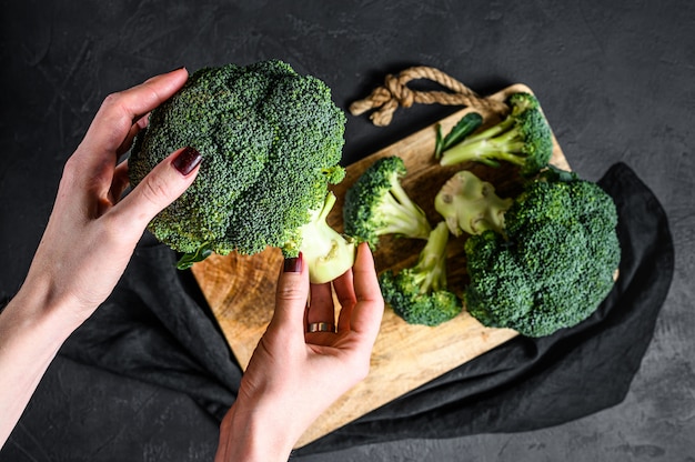 La jeune fille tient un brocoli frais.