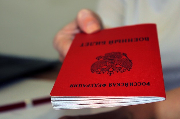 La jeune fille tient une carte d'identité militaire délivrée par la Fédération de Russie Le concept de mobilisation