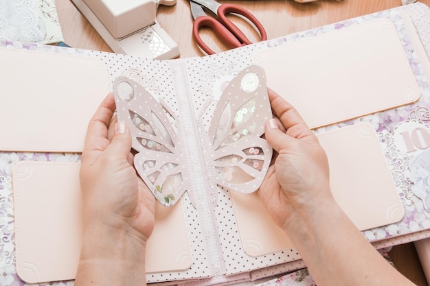 La jeune fille tient dans les mains des travaux manuels de scrapbooking pour mariage ou autres décorations festives Outils pour le scrapbooking DIY