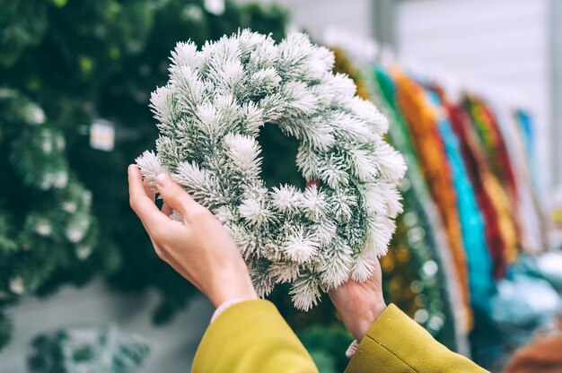 La jeune fille tient dans ses mains une nouvelle année, une couronne de Noël, des décorations pour la maison.