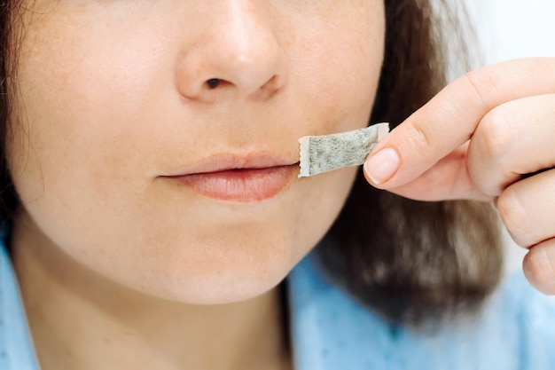 La jeune fille tient dans ses mains une pochette de nicotine snbcha oreiller