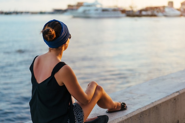 Jeune fille touristique brune se détendre près de la mer