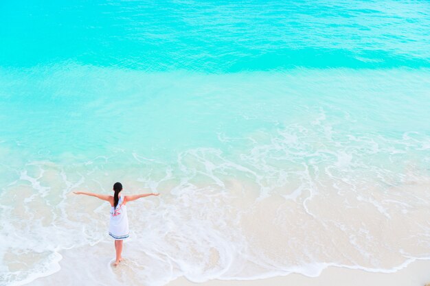 Jeune fille touristique heureuse à la plage s'amuser dans les eaux peu profondes. Vue de dessus d'une jeune fille et une plage blanche comme neige avec une eau turquoise.