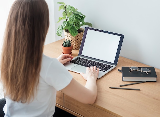 Jeune fille travaillant au bureau à domicile à la table