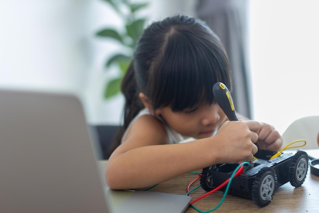 Une jeune fille travaillant sur une conception de robot.
