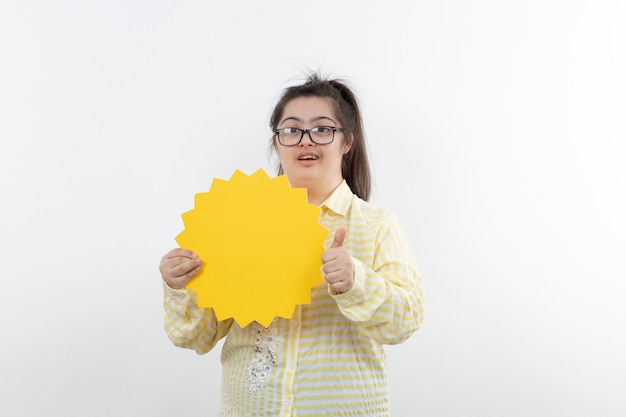 Jeune fille trisomique avec bulle de dialogue jaune posant.