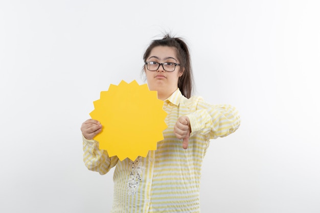 Jeune fille trisomique avec bulle de dialogue jaune posant.