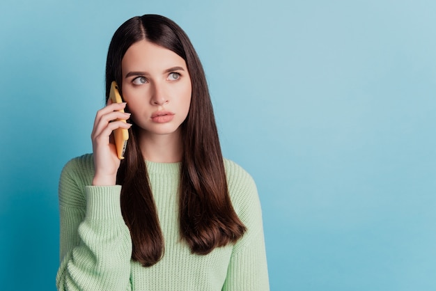 Jeune fille triste parler téléphone isolé sur fond bleu