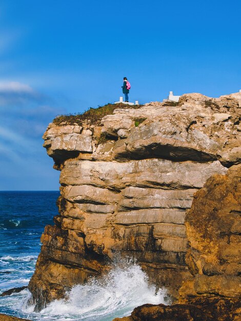 Photo une jeune fille trouve du réconfort dans l'immensité de l'horizon et embrasse une contemplation sereine sur la falaise