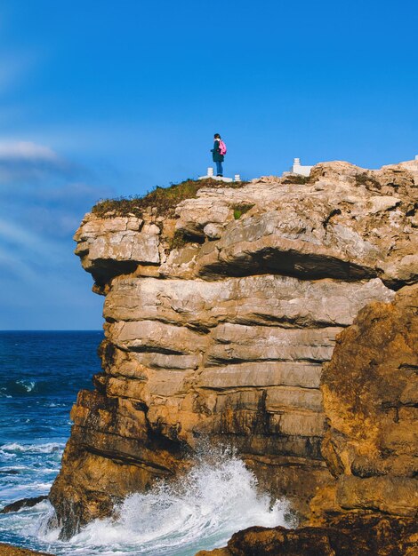 Une jeune fille trouve du réconfort dans l'immensité de l'horizon et embrasse une contemplation sereine sur la falaise