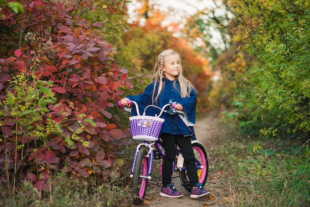 Jeune fille avec un vélo à l'extérieur dans le parc
