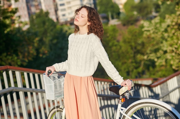 Une jeune fille avec un vélo profitant d'une matinée