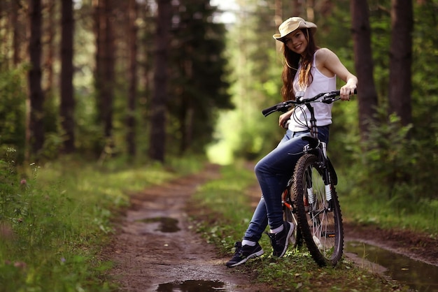 jeune fille sur un vélo de sport dans une forêt d'été