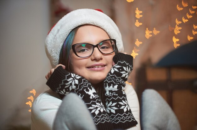 Jeune fille ventouses visage avec des mains portant chapeau de Noël.