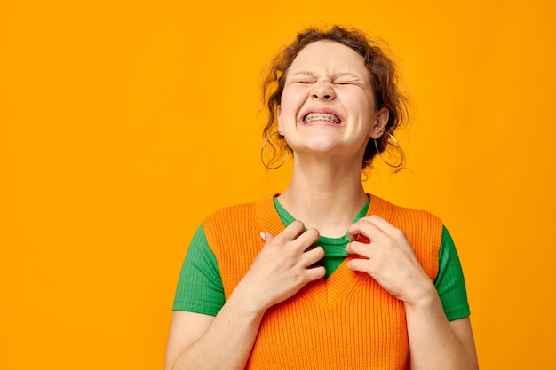 jeune fille en vêtements de jeunesse chandail orange posant fond isolé. Photo de haute qualité