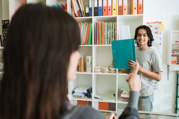 Jeune fille visitant une papeterie en choisissant l'article montrant les pouces